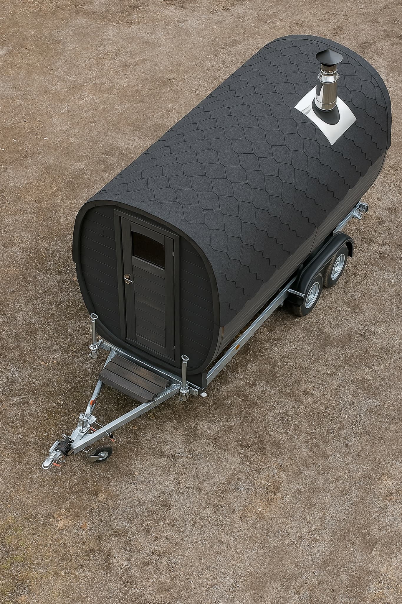 Bird's-eye view of a black barrel mobile sauna on a road-legal twin-axle trailer